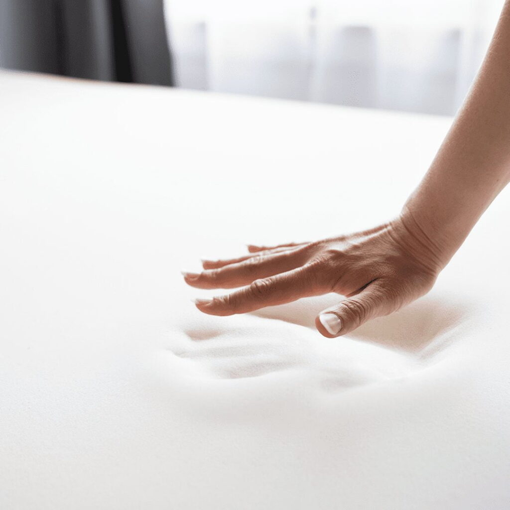 hand pressing into memory foam mattress