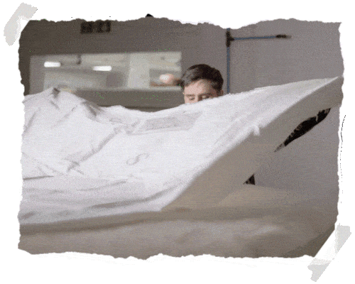 A person changing a bed sheet