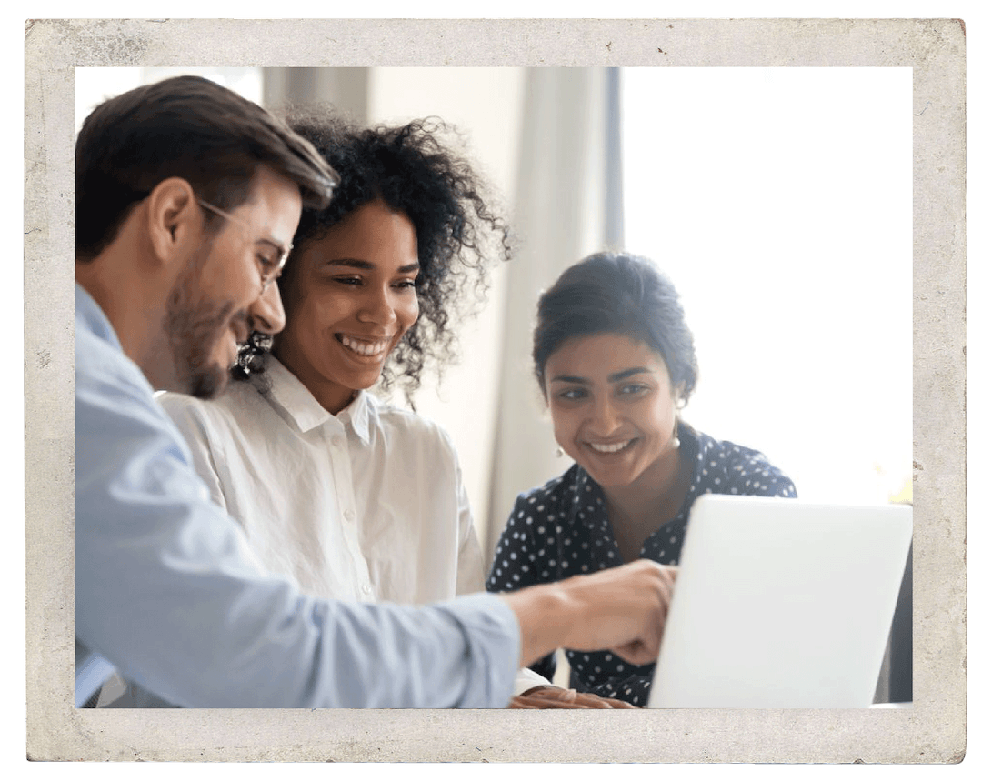 A smiling group looking a laptop screen